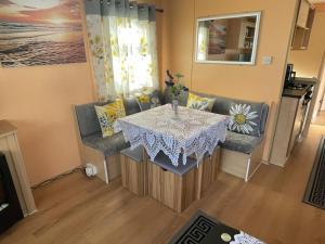 a dining room with a table and two chairs at Bright Family Caravan with Deck & BBQ at Seawick Holiday Park, Clacton in Clacton-on-Sea