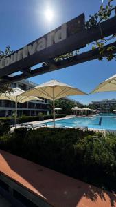 a swimming pool with umbrellas next to a building at CoyrtYard Longbeach Bölgesi İskele Mersin via 10 Cyprus 99850 TRNC Iskele in Iskele