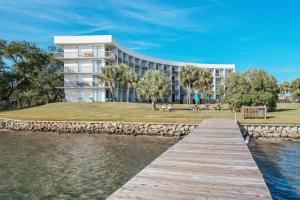 a building next to a body of water with a dock at Pirates Bay B303 in Fort Walton Beach