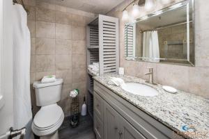 a bathroom with a toilet and a sink and a mirror at Pirates Bay A108 in Fort Walton Beach +39 photos