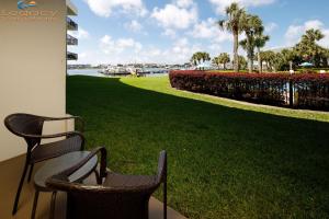 two chairs sitting on a porch next to a green lawn at Pirates Bay A108 in Fort Walton Beach