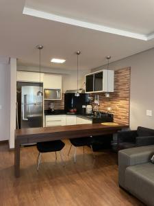 a kitchen with a large wooden table in a living room at Sequoia - Alphaville in Barueri