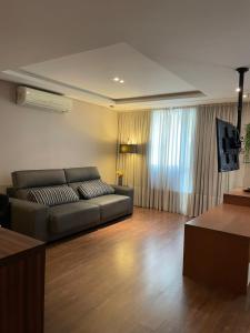 a living room with a couch and a television at Sequoia - Alphaville in Barueri