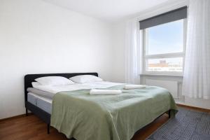 a bedroom with a bed with two towels on it at Helmi Pori Centrum in Pori