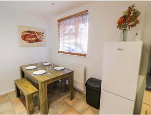 a small kitchen with a table and a refrigerator at Leamington Spa House with 4 Bedrooms in Leamington Spa