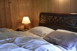 an unmade bed with a lamp on a table at La casa Chiappelle in Cortemilia +70 photos