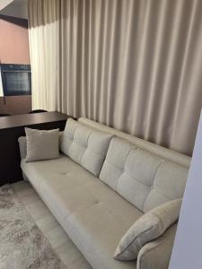 a white couch sitting in a room with a window at Deluxe Apartment 1 in Gnjilane