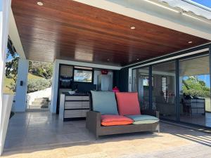 a covered patio with a chair and a desk at PROMONTOIRE DESIGN SUR MER in Le Gosier