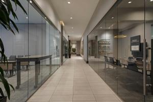 an office corridor with glass walls and a table and chairs at AC Hotel by Marriott Beverly Hills in Los Angeles