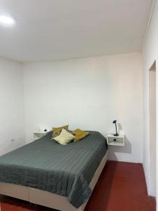 a white bedroom with a bed and two night stands at Bruma in Leones