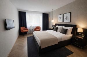 a hotel room with a large bed and a chair at Hotel Schwanenweiher Bad Bertrich in Bad Bertrich