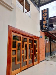 a pair of wooden doors on a building at Hotel Ostatus in El Pangui