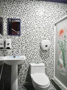 a bathroom with a toilet and a sink at Hotel Ostatus in El Pangui