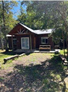 a log cabin with a porch and a yard at Casa familiar en parcela privada Pucón in Pucón