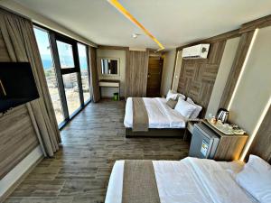 a hotel room with two beds and a flat screen tv at Alena Boutique Hotel in Aqaba