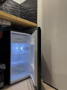 an empty refrigerator with its door open in a room at Tandem - Espacio para dos - Cama King - Parking in Maipú