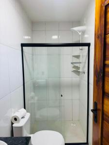 a bathroom with a glass shower with a toilet at Bigorú Flats in Itacaré