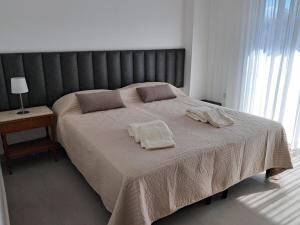 a bedroom with a large bed with two towels on it at Edificio Domum Urquiza 134 in San Juan