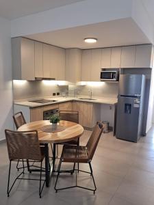 a kitchen with a table and chairs and a refrigerator at Edificio Domum Urquiza 134 in San Juan +7 photos