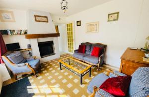 a living room with two chairs and a fireplace at Le Moulin L'Eveque in Campeaux