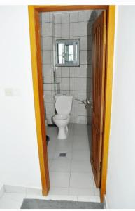 a bathroom with a toilet and a window at Résidence PAYAN in Douala