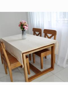 a table and chairs with a vase with flowers on it at Résidence PAYAN in Douala