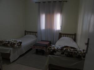 a bedroom with two beds and a window with curtains at Bed and breakfast in Ifrane +6 photos