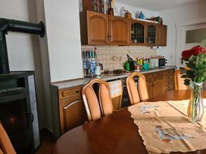 a kitchen with a wooden table with a vase of flowers at Waldbühnenblick in Schwarzenberg/Erzgebirge
