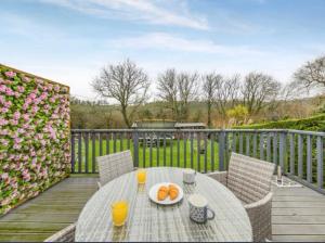 a table with a plate of oranges on a deck at Pinecroft in Pembrokeshire
