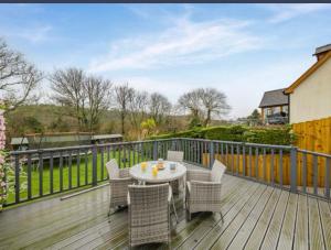 a patio with a table and chairs on a deck at Pinecroft in Pembrokeshire