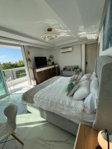 a bedroom with a large bed and a television at Ritacuba House Boutique in Santa Marta