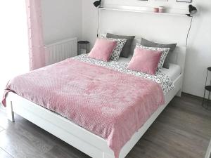 a bedroom with a white bed with pink sheets and pillows at SvjetlanAlex 2 in Banja Koviljača