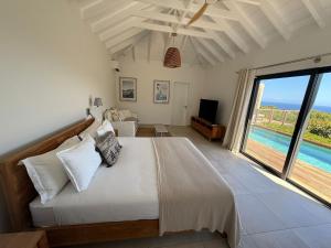 a bedroom with a bed and a view of the ocean at Spacious Modern Villa with Pool & Sunrise View - Graviola St Barth in Marigot +30 photos