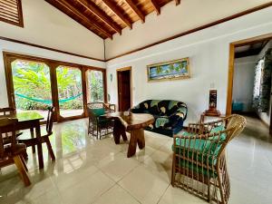 a living room with a couch and a table and chairs at Casa Lucas in Cahuita