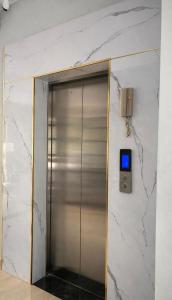 a elevator in a building with a sign on a wall at Cybade Hôtel in Phú Quốc