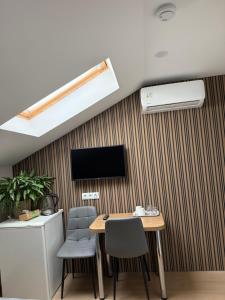 a room with a table and chairs and a tv on a wall at Bazar Motel in Chişinău