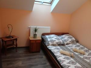 a small bedroom with a bed and a table at Agroturystyka ZIELONA ZAGRODA w Kosztowej in Dubiecko