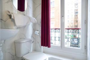 a bathroom with a toilet and a window at Hotel de Nantes in Paris
