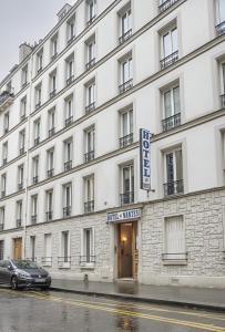 a large white building with a car parked in front at Hotel de Nantes in Paris