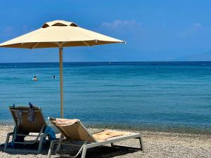 two chairs and an umbrella on a beach at MarieChristine Suites in Mesongi