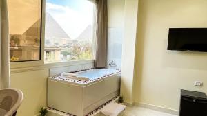 a bathroom with a bath tub in a window at Queen Inn Pyramids View in Cairo