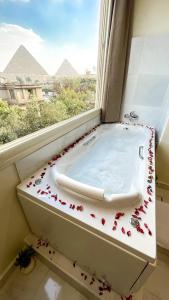a bath tub in a window with flowers on it at Queen Inn Pyramids View in Cairo +128 photos