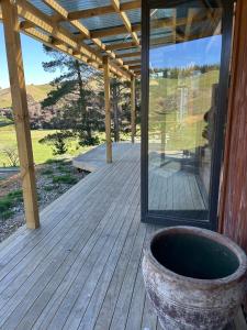 a wooden deck with a window and a pot on it at Mountain Range Guesthouse in Dovedale