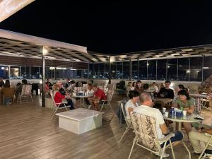 a group of people sitting at tables in a restaurant at Alena Boutique Hotel in Aqaba
