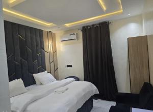 a hotel room with two beds and a black curtain at Moor Times Hotel in Benin City +4 photos