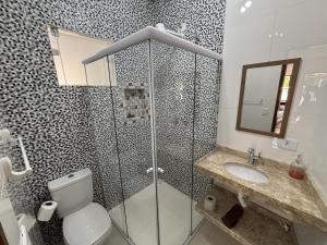 a bathroom with a shower and a toilet and a sink at Chalé Encanto Paraty in Paraty +18 photos