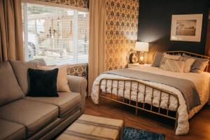 a bedroom with a bed and a couch and a window at Taylor Creek Lodge in Gold Beach
