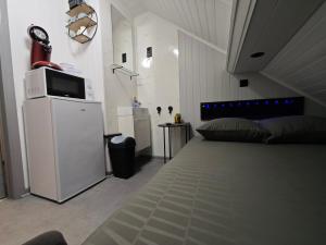 a bedroom with a bed with a microwave on a refrigerator at Budget-Room 2p in Ostend