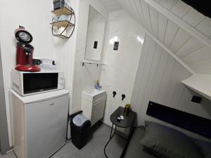 a small white room with a bed and a microwave at Budget-Room 2p in Ostend