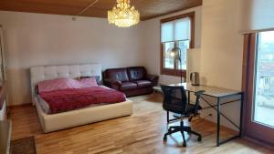 a bedroom with a bed and a desk and a chair at room for rent in Bolligen